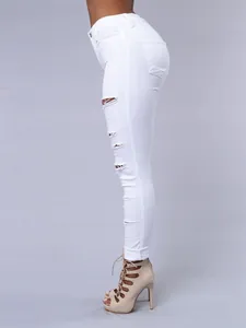 Vue latérale d'un jean skinny blanc déchiré pour femme avec des sandales à talons hauts.