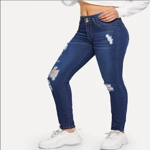 Detail view of women's stretch ripped skinny jeans with high waist and distressed accents