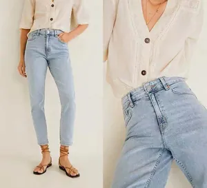 Close-up of high-waist fit and light blue wash on slim straight-leg denim jeans
