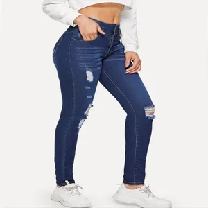 Close-up of distressed blue denim skinny jeans with ripped details on the knees
