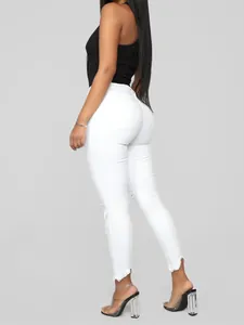 Vista lateral detallada de vaqueros skinny blancos de cintura alta con rotos en rodillas