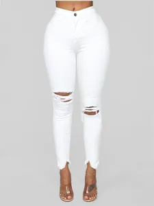 Vista detallada de vaqueros skinny blancos rotos de tiro alto con dobladillos deshilachados