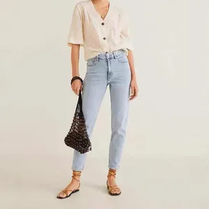 Women's high waisted slim straight light blue denim jeans in a casual outdoor setting