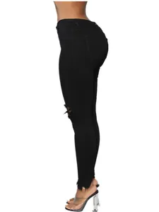 Vista lateral de vaqueros pitillo negros para mujer con rodilla rota y bajo deshilachado