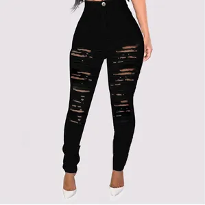 Detailed view of women's high waisted black distressed skinny jeans with ripped denim style
