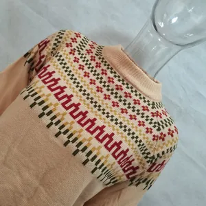 Primo piano di un maglione invernale con motivo geometrico a maglia colorata e lupetto