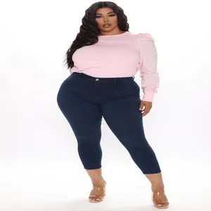 Vista completa di jeans skinny blu scuro a vita alta da donna curvy in studio.