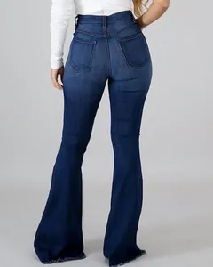 Detalle de vaqueros acampanados azul oscuro de talle alto con bajos deshilachados.
