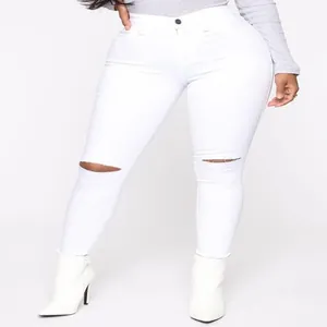 Primo piano di jeans skinny bianchi a vita alta da donna con dettaglio ginocchio rotto