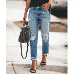 Street style view of women's ripped straight-leg jeans with frayed hem details.