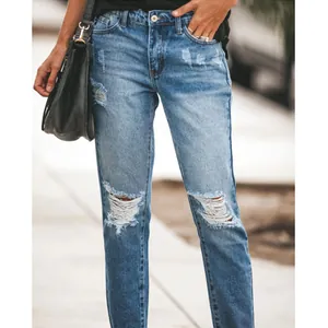 Detailed view of women's blue distressed straight-leg denim jeans with knee rips