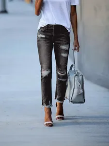 Women's black distressed straight-leg denim jeans with ripped details and frayed hem