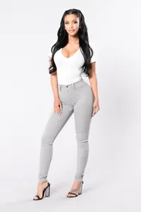 Detail view of light grey high-waisted stretch skinny jeans for women on model.