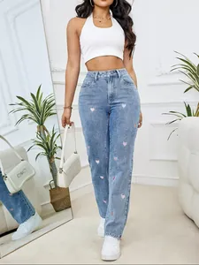 Dettaglio ravvicinato del ricamo a cuore rosa su jeans denim a gamba dritta a vita alta