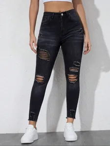 Detail der schwarzen Ripped-Jeans in Slim Fit mit Distressed-Textur und Löchern