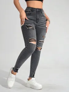 Detailansicht der grauen High-Waist-Skinny-Jeans mit modischen Rissen und Distressed-Look