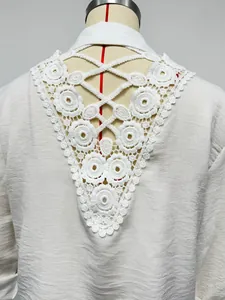 Close-up detail of exquisite white lace embroidery on the back of a casual blouse