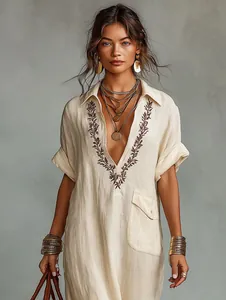 Close-up detail of embroidered floral pattern on bohemian linen cotton maxi dress