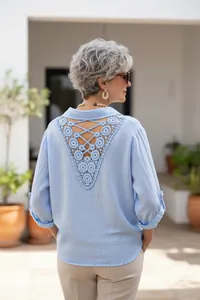 Detail of the elegant blue linen shirt featuring an intricate crochet lace-up back design