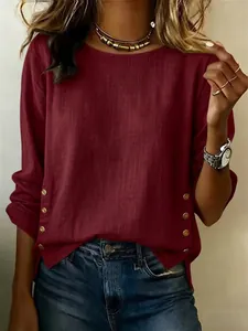 Detailed view of wine red cotton linen top featuring decorative side gold buttons