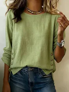 Detail shot of green cotton linen top showing decorative buttons and fabric texture
