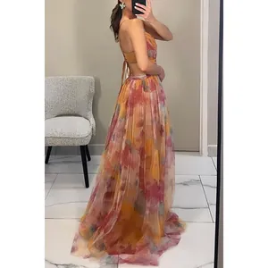 Close-up of backless mesh maxi dress with colorful floral print and tie straps