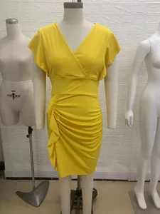 Detalle de un vestido ajustado amarillo brillante con cuello en V y volantes