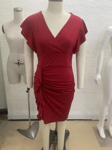 Detalle de vestido rojo con cuello en V, mangas con volantes y fruncido lateral en maniquí