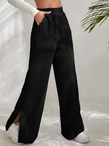 Close-up detail of women's black high-waisted corduroy trousers featuring a stylish split hem design
