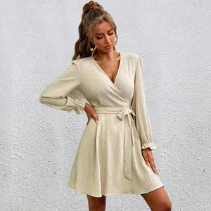 Close-up detail of beige wrap V-neck dress featuring belted waist and lantern sleeves