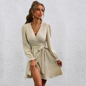 Close-up detail showing the textured fabric and lantern sleeves of the beige wrap dress