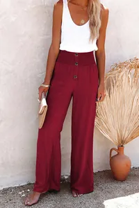 Close-up of wine red wide-leg linen pants featuring decorative buttons and waist