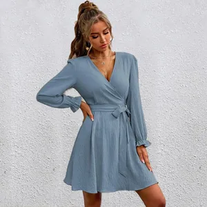 Detailed view of dusty blue long sleeve wrap dress with waist tie and ruffled cuffs