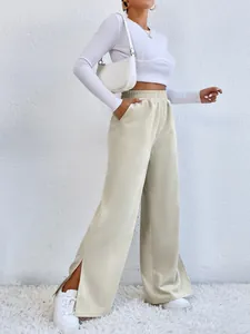 Detail view of women's beige corduroy high-waist pants with stylish side slit hem