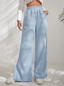 Detail view of light blue corduroy high waist wide leg trousers with split hem