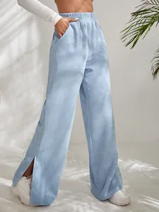 Close-up detail of light blue high-waist corduroy pants featuring a side slit hem.