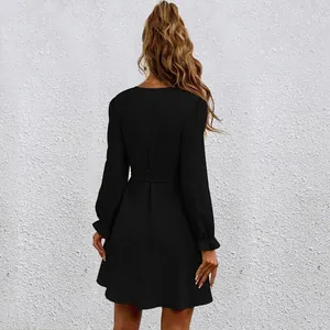 Back view of a black long-sleeved dress with belted waist and lantern sleeves