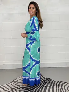 Side view of a blue tie-dye wide-leg jumpsuit with bell sleeves on a model.