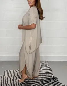 Side view of a beige plus-size loose short-sleeve top and split wide-leg trousers set