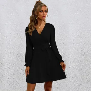 Detail of black V-neck wrap dress with lantern sleeves and adjustable waist tie