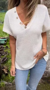 Close-up view of white waffle knit V-neck short sleeve top with wooden buttons.