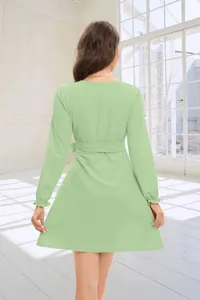 Back view of a sage green long sleeve mini dress with a belted waist and ruffled cuffs.