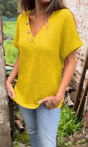 Close-up of women's yellow waffle knit V-neck T-shirt with stylish button details