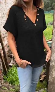 Close-up detail of women's black waffle knit T-shirt with V-neck and wood buttons.