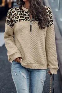 Detalle de sudadera de mujer con estampado de leopardo, textura acolchada y cremallera