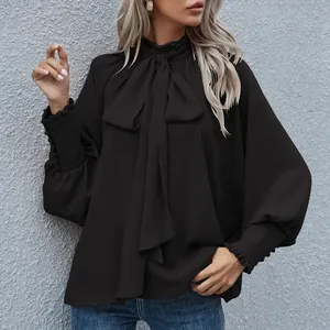 Detailaufnahme der eleganten schwarzen Bluse mit Stehkragen und Puffärmeln