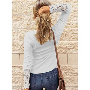 Detail of white long sleeve top with hollow-out lace cuffs and ribbed texture.