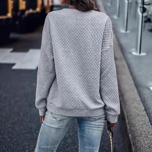 Sudadera de manga larga acolchada gris para mujer en un entorno exterior urbano