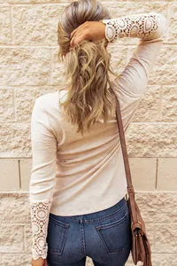 Detailed back view of a ribbed beige long sleeve top with elegant crochet lace cuffs