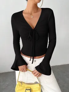 Close-up of black ribbed long sleeve top with bell sleeves and V-neck tie-front detail